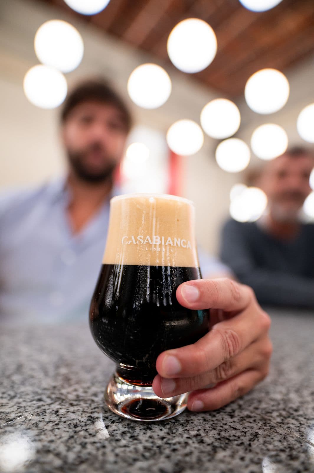 Cerveza negra en copa de Lisería Casabianca sobre la barra de granito