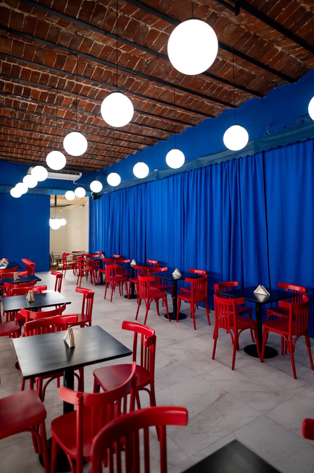 Salón de Lisería Casabianca con sillas rojas y cortinas azules